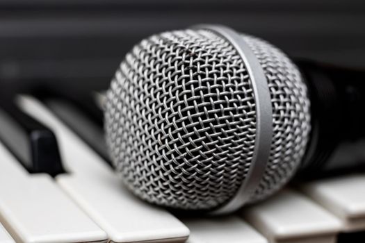 Microphone lies on the piano keys close up, macro photo