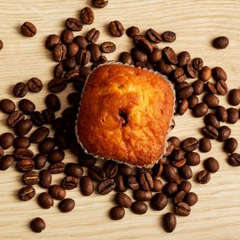 Cupcake with chocolate and coffee beans on a wooden table