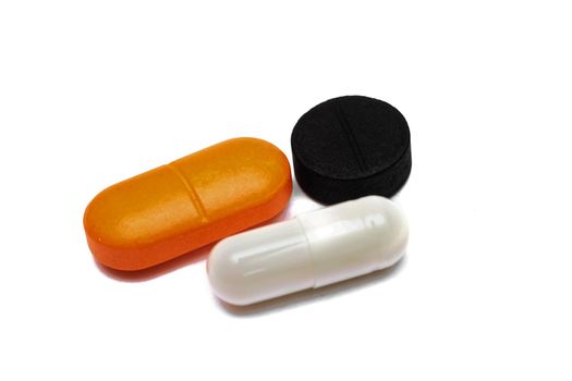 Three colored pills close up, isolate on a white background