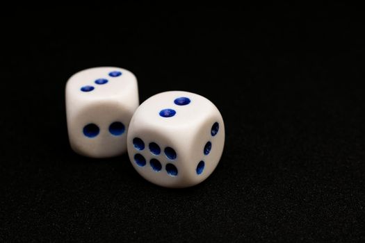 Two white dices on a black background, with copy cpace