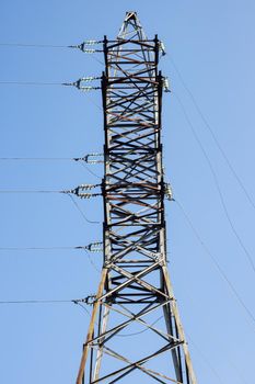 Metal pole with electrical networks on a blue sky background close up