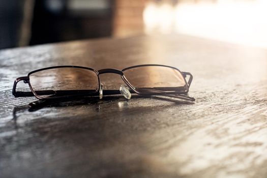 Glasses on a wooden table close up, the sun's rays from the window