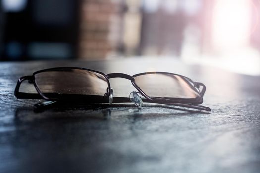 Glasses on a wooden table close up, the sun's rays from the window