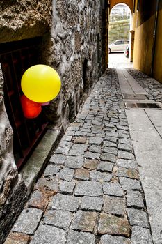 Colorful balloons tied on fenche of facade of  narrow street of Miragaia in Porto city, Portugal