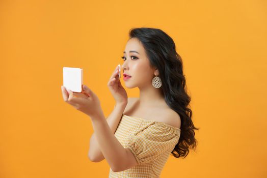 Portrait Of Young Woman Putting Makeup Powder With Cosmetic Cushion On Her Facial Skin 