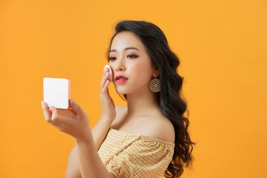 Closeup Of Sexy Female Applying Dry Powder Foundation Looking In Mirror.