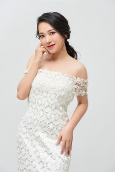 Beautiful bride dressed in a white dress on white background. 