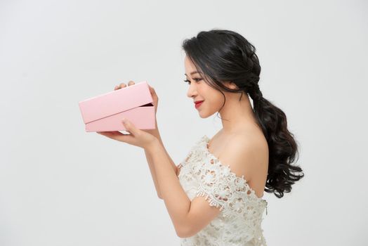 attractive smile surprised beautiful woman bride with makeup in chic sexy white wedding holding gift box