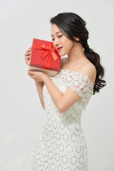 holidays, presents, wedding and happiness concept - smiling woman in white dress holding red gift box 