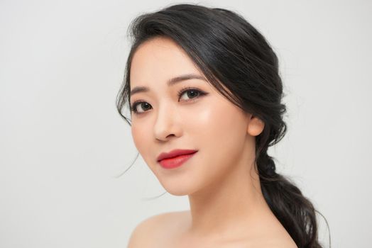 Closeup young romantic lady in wedding festive dress standing indoors on light background, pretty woman posing