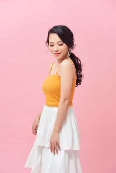 Debonair asian girl in long skirt posing in studio.