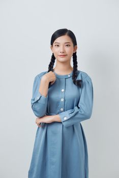 Young woman with pigtails daydreaming against white background