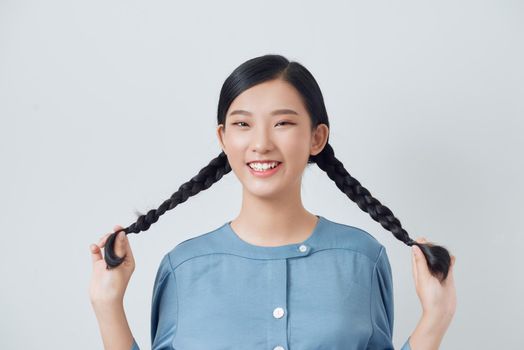 Young cheerful girl having fun. Smiling Woman with bright makeup and hairstyle with pigtails