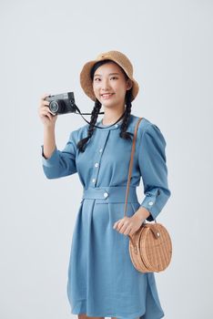 Young Asian woman holding a vintage camera on white background