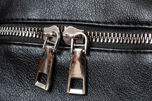 Metal clasp and zipper on leather close up