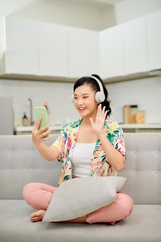 Female housewife talking via messenger app having video chat on mobile phone