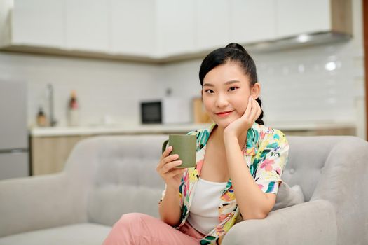 Woman drinking coffee on sofa