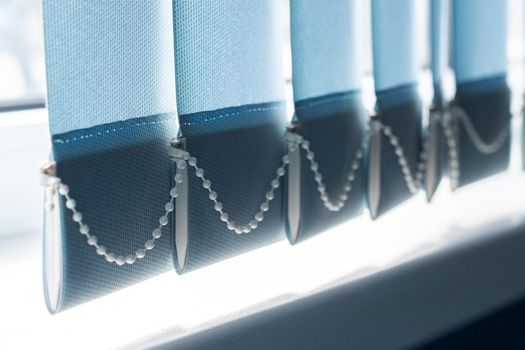 Blue fabric blinds on the window close up, sunlight