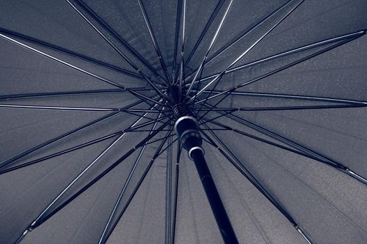 Big black umbrella bottom view close up, with copy space
