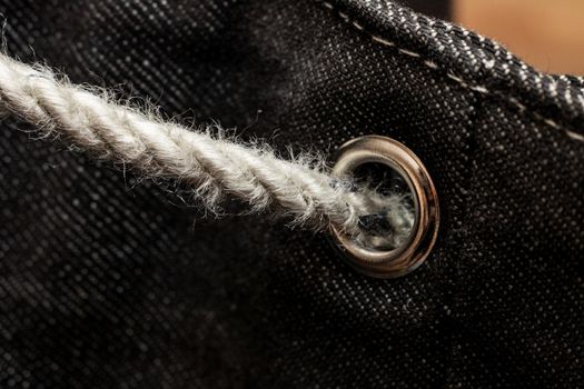 Buckle on a gray denim backpack close up, copy space