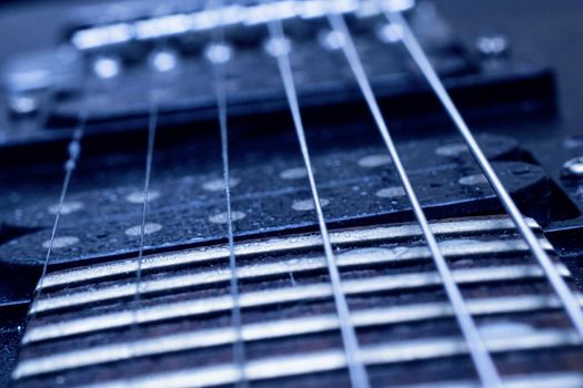 Strings on a black guitar close up, macro photo