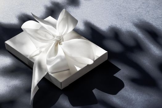 Anniversary celebration, shop sale promotion and luxe surprise concept - Luxury holiday white gift box with silk ribbon and bow on black background, luxe wedding or birthday present