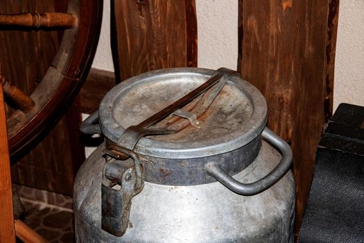 Large old metal tank on the background of a wooden wall close up