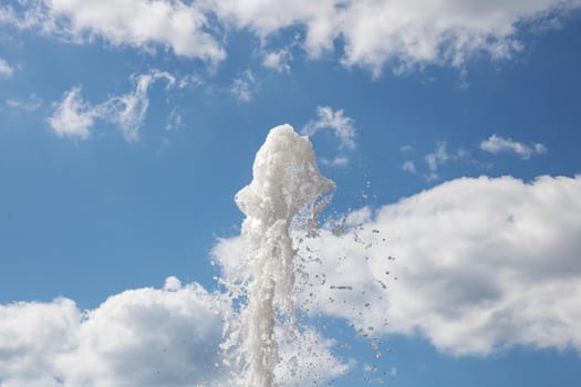 Spray of water from the fountain on the background of blue sky close up