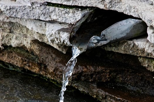 Stream of water in the spring on the stones close up