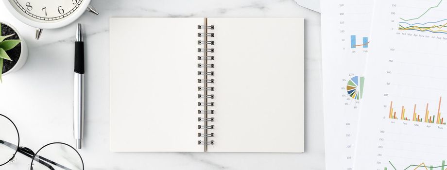 Top view of office table desk work concept with blank notebook, report, alarm clock on marble white background, concept of timing management and schedule planning.