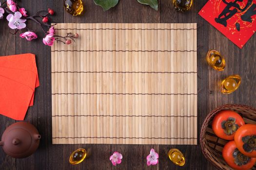 Top view of fresh sweet persimmons kaki with leaves on wooden table background for Chinese lunar new year fruit design concept, the word means blessing is coming.
