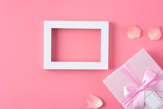 Valentine's Day design concept background with pink petals and gift box on pink background