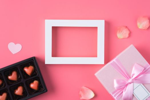 Valentine's Day design concept background with pink petals and gift box on pink background