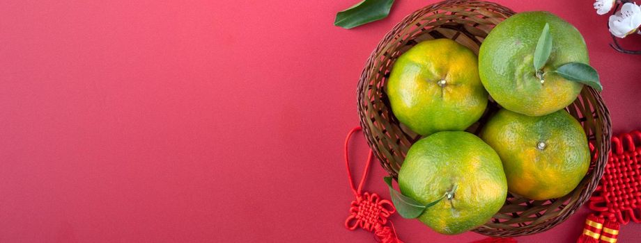 Top view of fresh ripe tangerine mandarin orange with fresh leaves on red table background for Chinese lunar new year fruit concept, the Chinese word means spring.