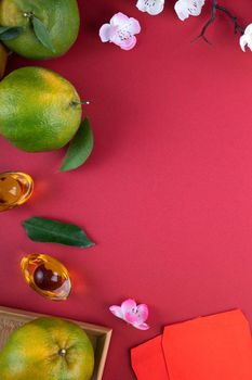 Top view of fresh ripe tangerine mandarin orange with fresh leaves on red table background for Chinese lunar new year fruit concept, the Chinese word means spring.
