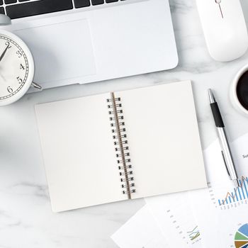 Top view of office table desk work concept with blank notebook, report, alarm clock on marble white background, concept of timing management and schedule planning.