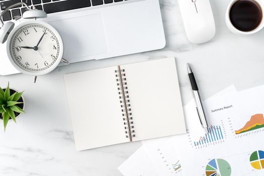 Top view of office table desk work concept with blank notebook, report, alarm clock on marble white background, concept of timing management and schedule planning.