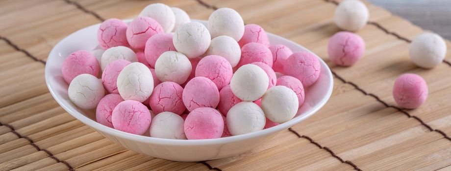 Raw red and white tangyuan glutinous rice dumpling balls on wooden table background for Winter solstice festival food.