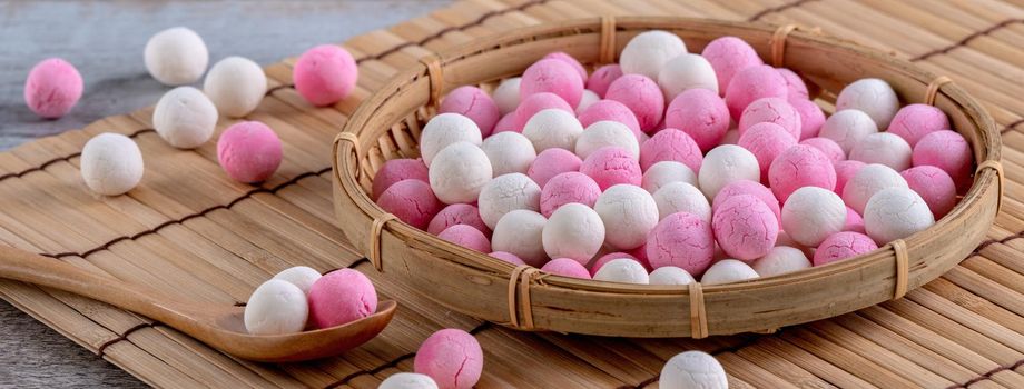 Raw red and white tangyuan glutinous rice dumpling balls on wooden table background for Winter solstice festival food.