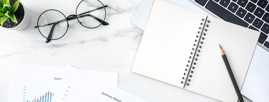 Top view of office table desk work concept with blank notebook, report, alarm clock on marble white background, concept of timing management and schedule planning.