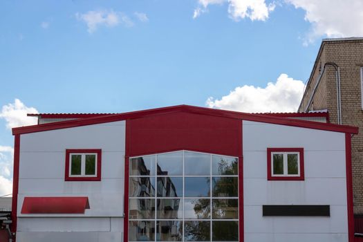 Exterior view of a modern light red city building with large glass showcases.