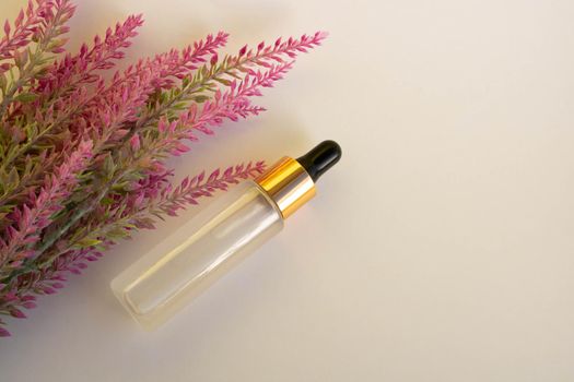 A bottle of cosmetic liquid transparent gel next to a branch of artificial lavender on a white background. Flat styling style. Place for your text.