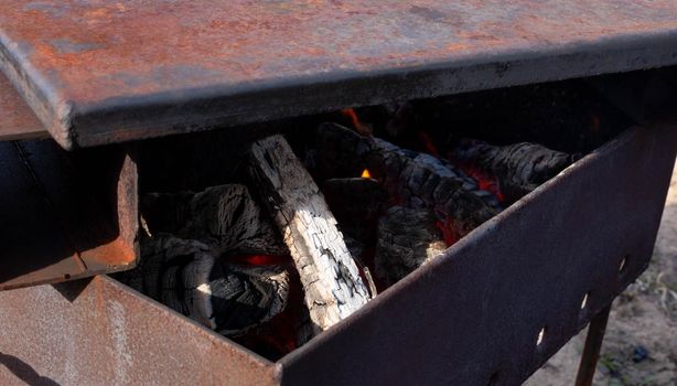 Makeshift iron smokehouse with Lid full of hot charcoal for Smoking Fish.