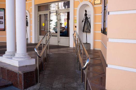 Entrance to the theater with steel handrails and a gentle ramp for children and wheelchairs.