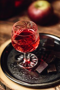 Homemade berry alcoholic beverage and chocolate bars on metal tray