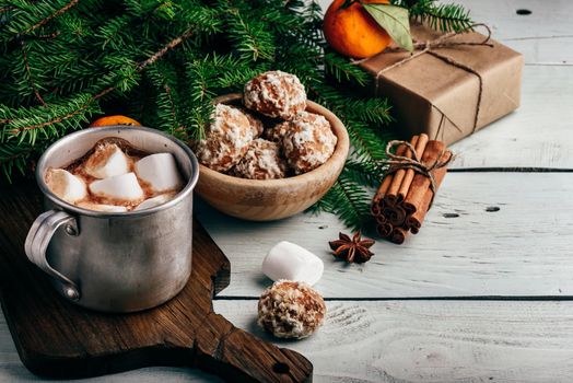 Rustic mug of hot chocolate with marshmallows on cutting board