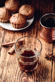 Turkish coffee with spices and oatmeal muffins on wooden surface