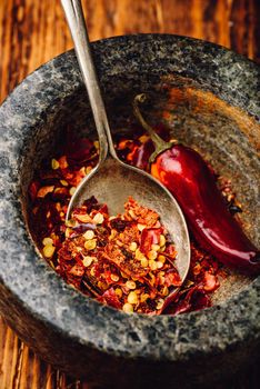 Crushed red chili pepper in stone mortar