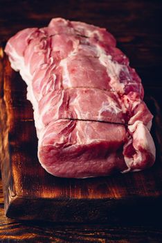 Pork loin joint on rustic cutting board