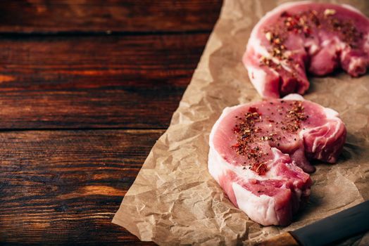 Pork loin steaks with ground spices on baking paper